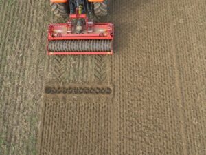 Kverneland H series zapojená za traktor pri práci na poli